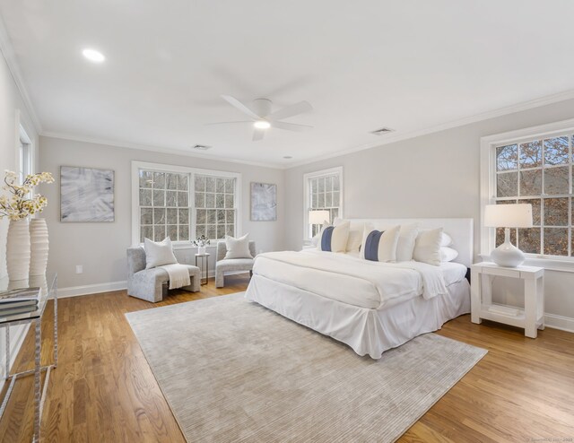 bedroom featuring light hardwood / wood-style flooring, ceiling fan, and crown molding