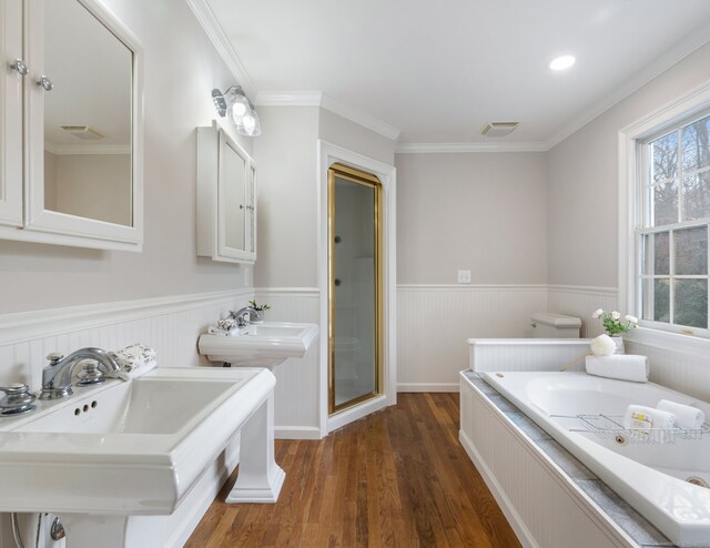 bathroom with plus walk in shower, hardwood / wood-style floors, dual sinks, and ornamental molding