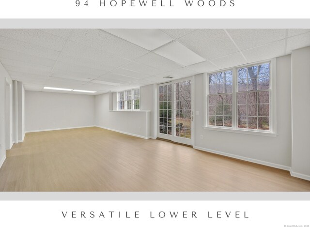 spare room featuring hardwood / wood-style flooring and a drop ceiling