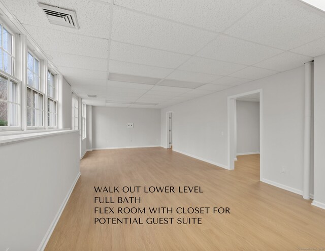 interior space with a paneled ceiling and light hardwood / wood-style flooring