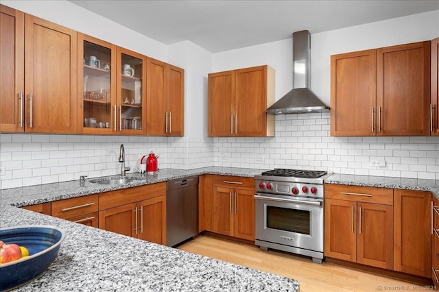 kitchen featuring backsplash, wall chimney range hood, and stainless steel appliances