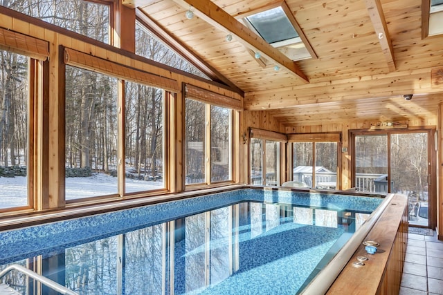 snow covered pool featuring a skylight and a hot tub