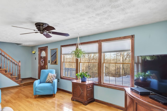 sitting room featuring ceiling fan, a textured ceiling, and light wood-type flooring