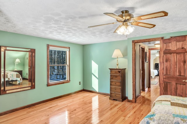 bedroom featuring a textured ceiling, light hardwood / wood-style floors, and ceiling fan