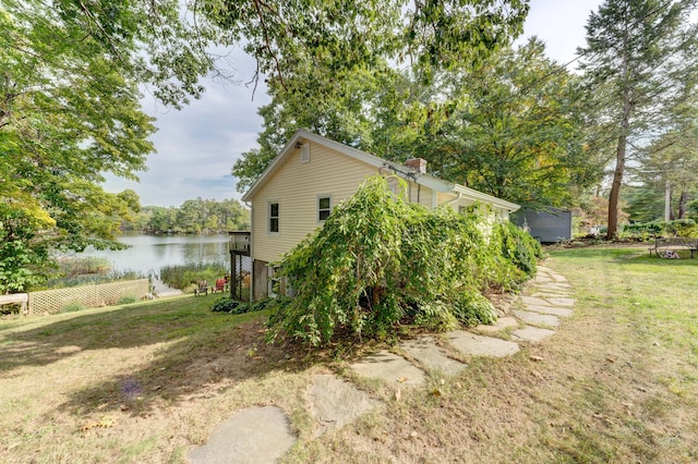 view of home's exterior featuring a lawn and a water view