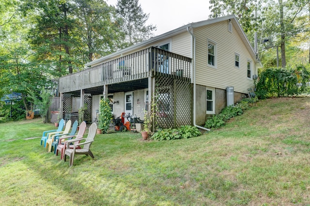 rear view of house featuring a lawn and a wooden deck