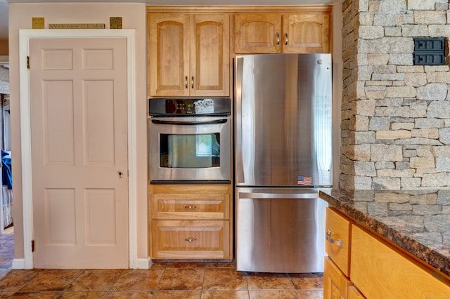 kitchen with stainless steel appliances and dark stone counters