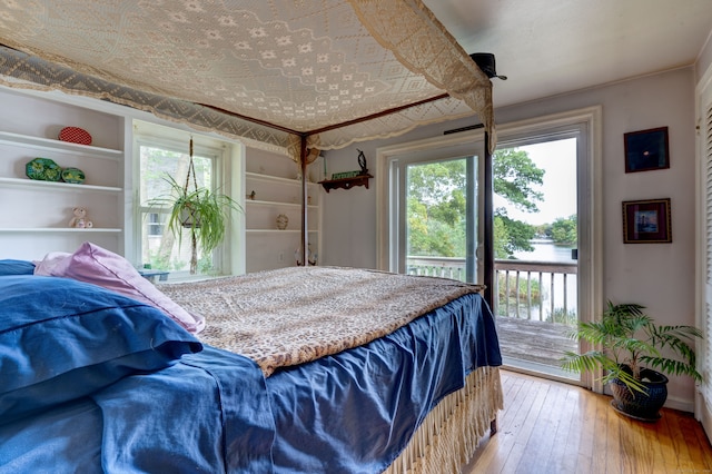 bedroom with access to outside and hardwood / wood-style flooring