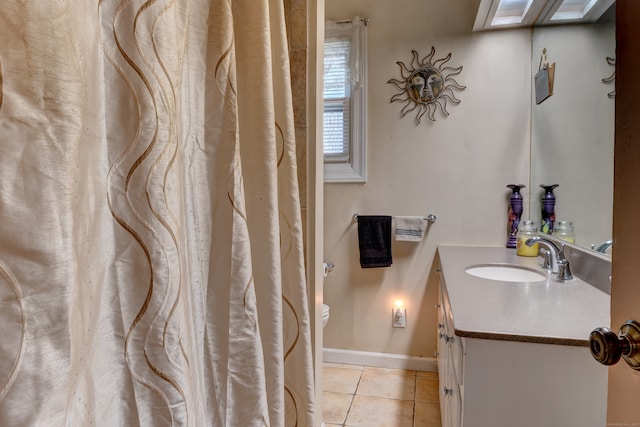 bathroom with tile patterned floors, a skylight, and vanity