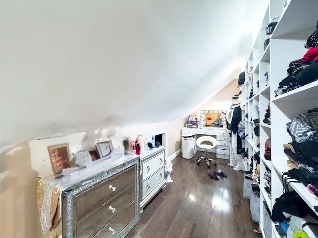 spacious closet featuring dark hardwood / wood-style floors and lofted ceiling