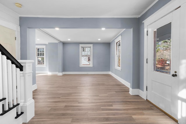 entryway with crown molding and light hardwood / wood-style flooring