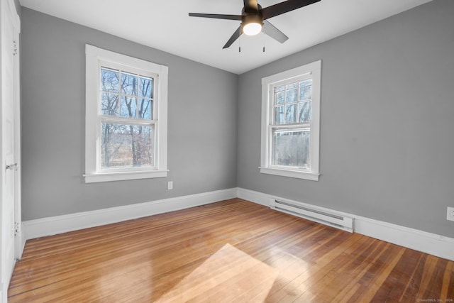 empty room featuring baseboard heating, ceiling fan, and light hardwood / wood-style flooring