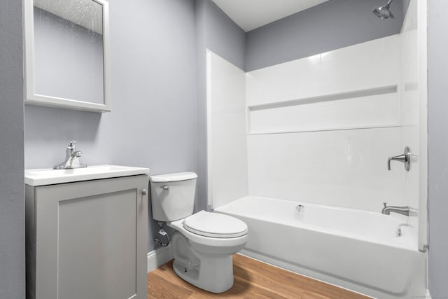 full bathroom with shower / tub combination, vanity, hardwood / wood-style flooring, and toilet