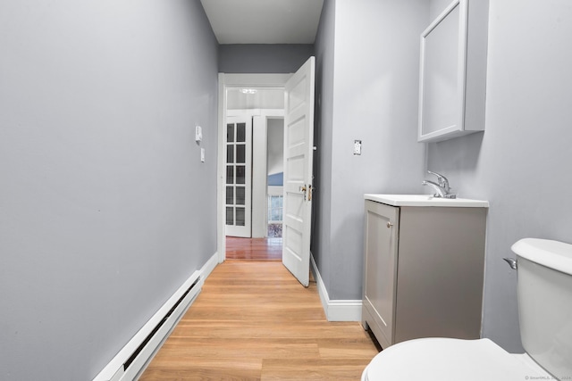 bathroom featuring hardwood / wood-style floors, vanity, toilet, and a baseboard radiator