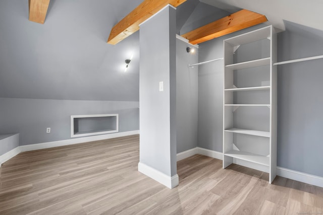 additional living space with light hardwood / wood-style flooring and lofted ceiling