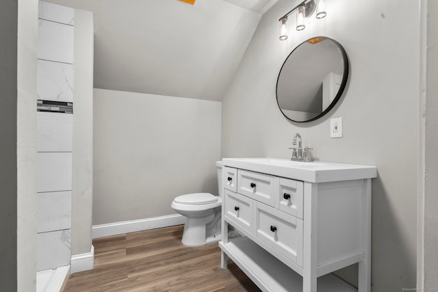 bathroom with toilet, vanity, lofted ceiling, and hardwood / wood-style flooring