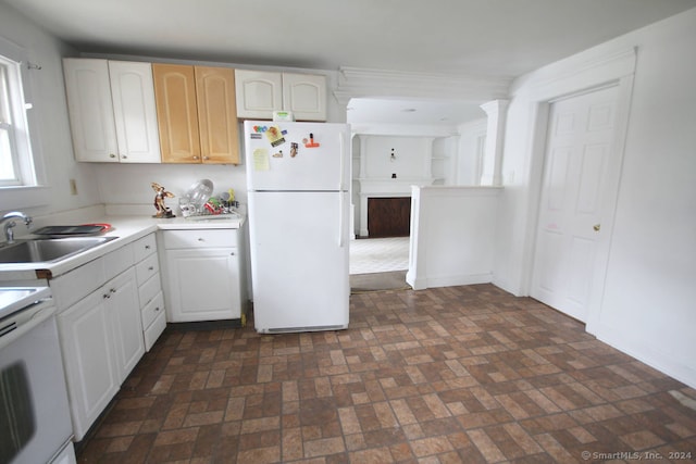 kitchen featuring sink, white cabinets, and white appliances