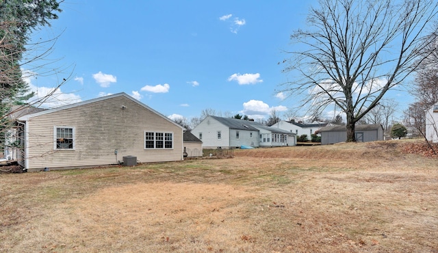 back of property with a yard and central AC unit