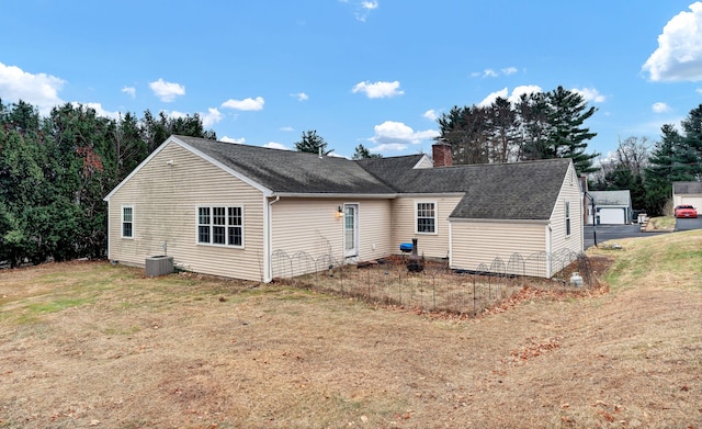 back of property with a yard and central air condition unit