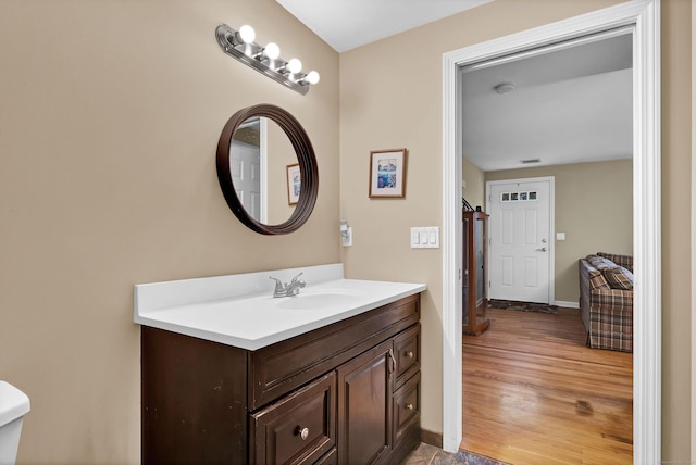 bathroom with vanity, hardwood / wood-style flooring, and toilet