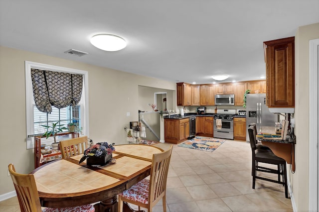 dining space featuring sink and light tile patterned flooring