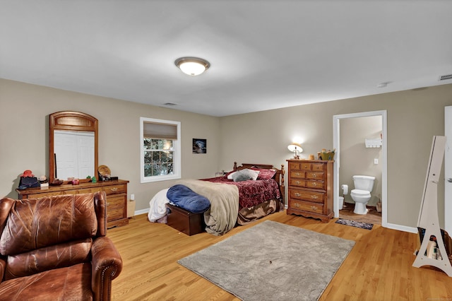 bedroom with light hardwood / wood-style floors and ensuite bath