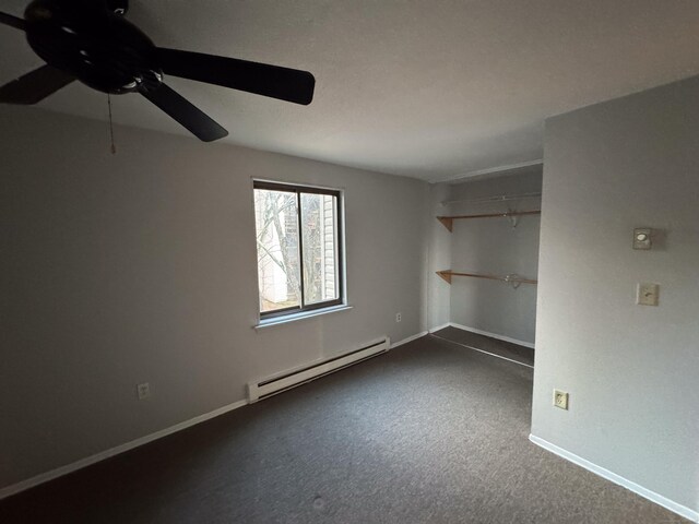 spare room featuring dark colored carpet, ceiling fan, and a baseboard radiator