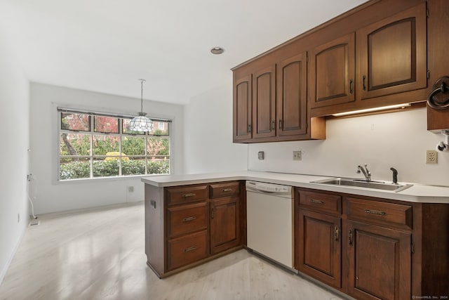 kitchen with dishwasher, sink, a notable chandelier, kitchen peninsula, and pendant lighting