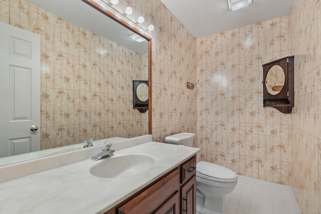 bathroom featuring tile patterned floors, vanity, tile walls, and toilet