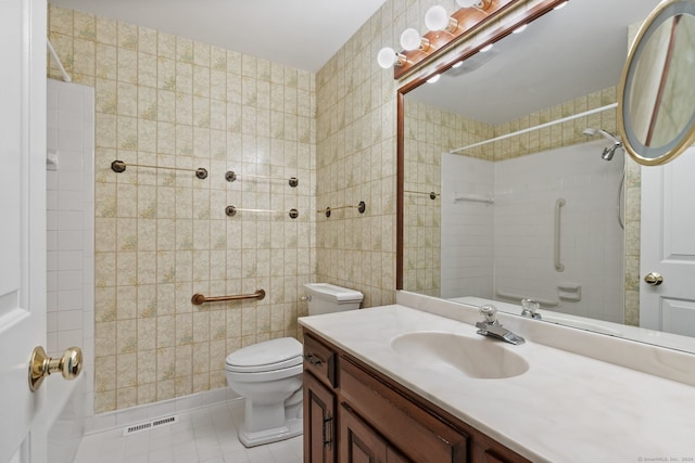 bathroom with tile patterned flooring, vanity, toilet, and tile walls