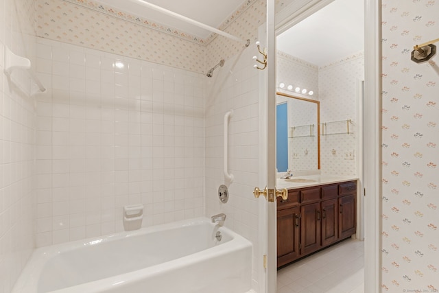 bathroom featuring tile patterned flooring, vanity, and tiled shower / bath