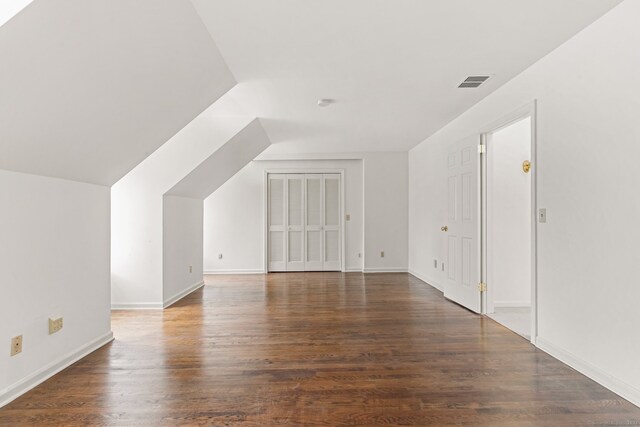 additional living space featuring dark hardwood / wood-style flooring and lofted ceiling