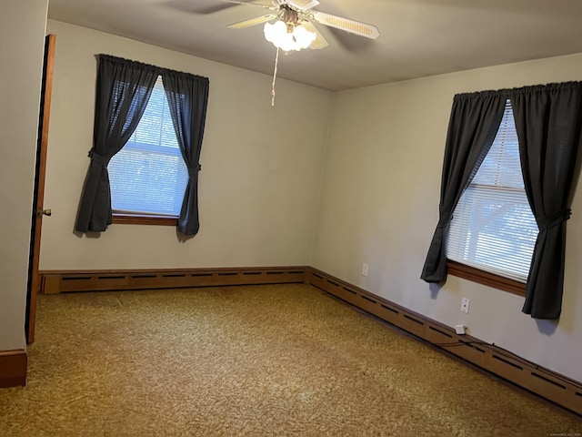 carpeted empty room featuring baseboard heating and ceiling fan