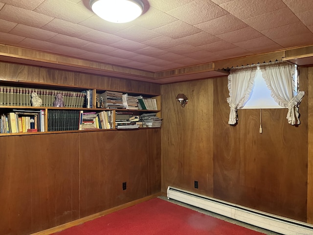 unfurnished room featuring wooden walls and baseboard heating