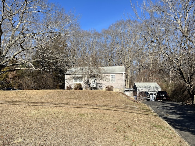 view of front of house featuring an outdoor structure and a front yard