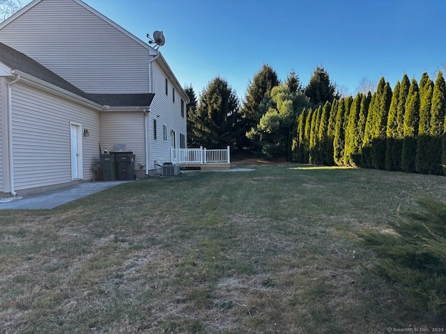 view of yard featuring a patio, a deck, and central air condition unit