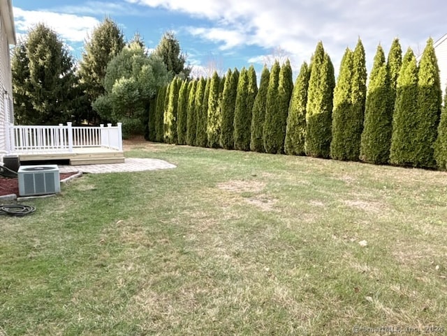 view of yard featuring a wooden deck and central AC unit