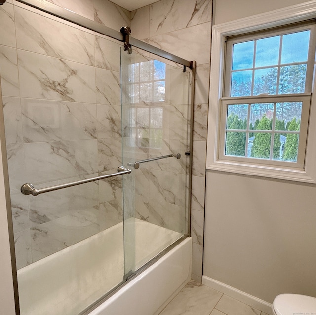 bathroom featuring tile patterned floors, enclosed tub / shower combo, and toilet