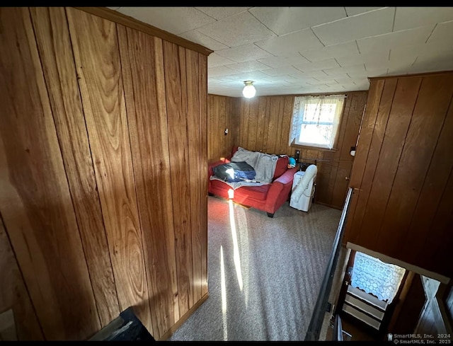 carpeted bedroom featuring wooden walls