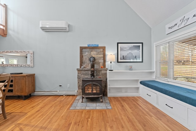 sitting room featuring a wood stove, a wall mounted air conditioner, light hardwood / wood-style flooring, high vaulted ceiling, and a baseboard heating unit