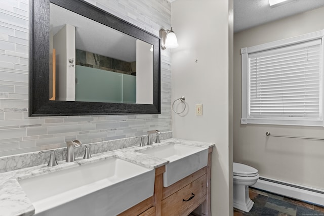 bathroom with baseboard heating, tasteful backsplash, a textured ceiling, toilet, and vanity