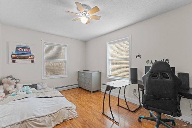 bedroom featuring ceiling fan, a textured ceiling, a baseboard radiator, and light hardwood / wood-style flooring