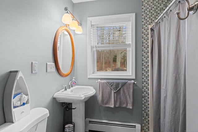 bathroom featuring sink, toilet, baseboard heating, and walk in shower