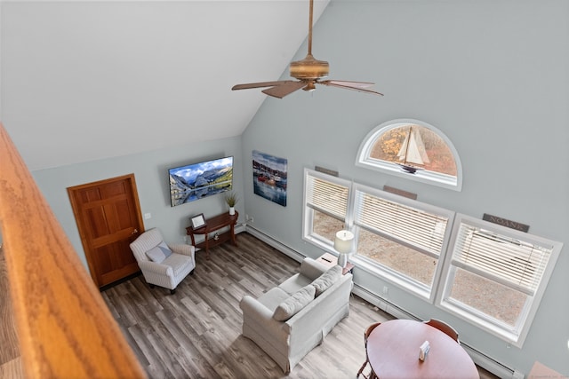 living room featuring hardwood / wood-style floors, ceiling fan, and a baseboard heating unit