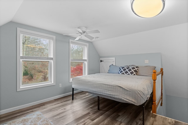 bedroom with ceiling fan, hardwood / wood-style floors, and vaulted ceiling