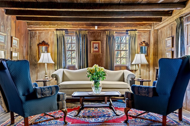 sitting room with wooden walls, beamed ceiling, and wooden ceiling