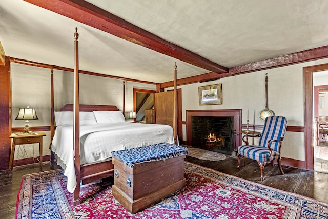 bedroom featuring beam ceiling and dark hardwood / wood-style floors