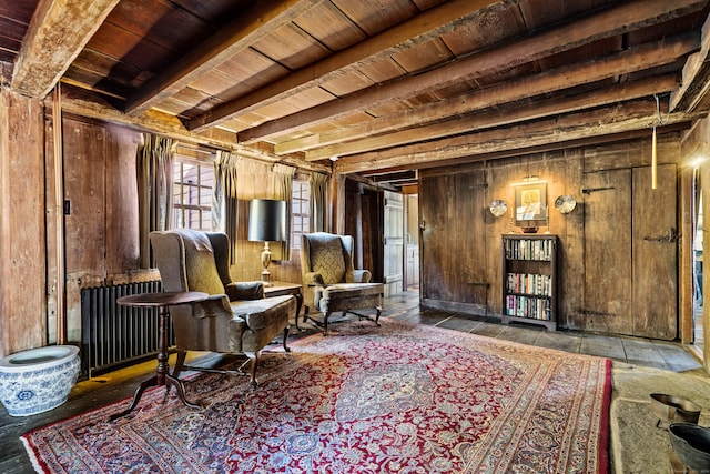 living area with beam ceiling, radiator, wooden ceiling, and wood walls