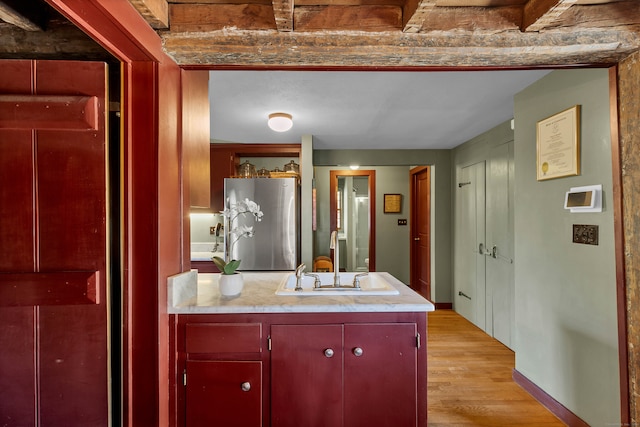 bathroom featuring hardwood / wood-style floors, vanity, and beamed ceiling