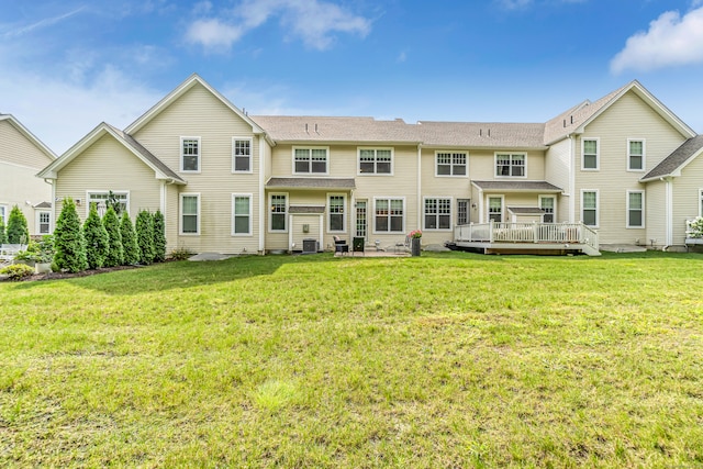 rear view of property with a yard and a wooden deck